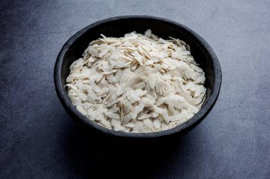 Çiğ pirinç ya da ince pirinç gevreği Namkeen Chivda atıştırmalıkları için ya da Hint kahvaltısı için Aloo Poha, bir kase içinde servis edilir.