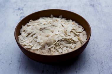 Çiğ pirinç ya da ince pirinç gevreği Namkeen Chivda atıştırmalıkları için ya da Hint kahvaltısı için Aloo Poha, bir kase içinde servis edilir.