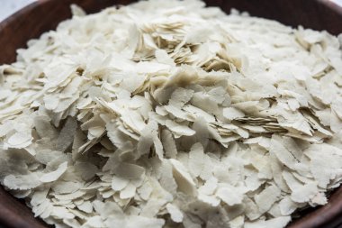 Çiğ pirinç ya da ince pirinç gevreği Namkeen Chivda atıştırmalıkları için ya da Hint kahvaltısı için Aloo Poha, bir kase içinde servis edilir.