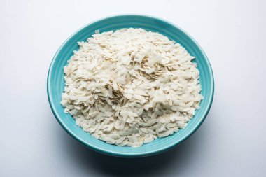 Çiğ pirinç ya da ince pirinç gevreği Namkeen Chivda atıştırmalıkları için ya da Hint kahvaltısı için Aloo Poha, bir kase içinde servis edilir.