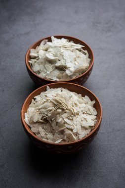 Çiğ pirinç ya da ince pirinç gevreği Namkeen Chivda atıştırmalıkları için ya da Hint kahvaltısı için Aloo Poha, bir kase içinde servis edilir.