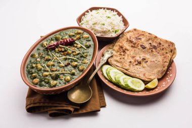 Nohut aromalı ıspanak körisi ya da Palak 'lı Chana Masala pilav ve düz ekmek ya da Paratha ile servis edilir.