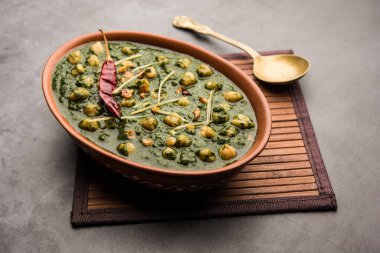 Nohut aromalı ıspanak körisi ya da Palak 'lı Chana Masala pilav ve düz ekmek ya da Paratha ile servis edilir.