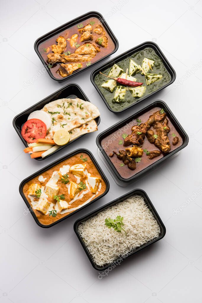 Online Food delivery concept Indian paneer butter masala and palak paneer, mutton & chicken curry with roti and rice in plastic containers, food like butter chicken, chicken
