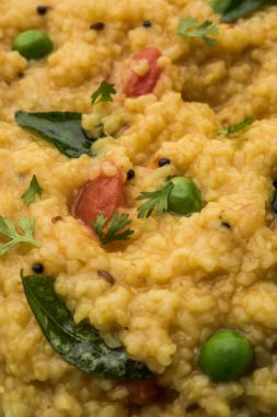 Sebze Dalia veya Daliya Khichadi veya Kırık Buğday Khichdi domates, yeşil bezelye ve biberli, bir kase veya tabakta servis edilir.