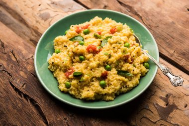 Sebze Dalia veya Daliya Khichadi veya Kırık Buğday Khichdi domates, yeşil bezelye ve biberli, bir kase veya tabakta servis edilir.