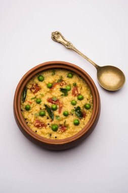 Sebze Dalia veya Daliya Khichadi veya Kırık Buğday Khichdi domates, yeşil bezelye ve biberli, bir kase veya tabakta servis edilir.