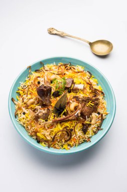 Restoran tarzı Gosht veya Mutton Biryani Raita ve Salan ile birlikte bir kasede servis edildi.