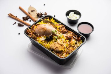 Restoran tarzı Tavuk Tikka Biryani Raita ve Salan ile birlikte plastik kutu veya konteynırda eve teslim edilmek üzere paketlendi.