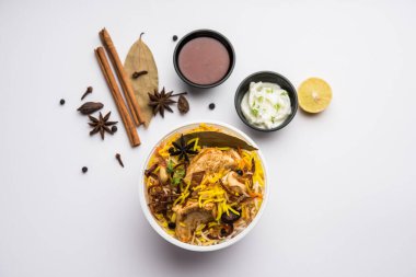 Restoran tarzı Tavuk Tikka Biryani Raita ve Salan ile birlikte plastik kutu veya konteynırda eve teslim edilmek üzere paketlendi.