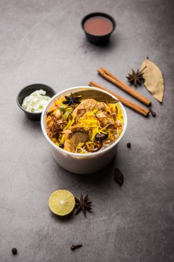 Restoran tarzı Tavuk Tikka Biryani Raita ve Salan ile birlikte plastik kutu veya konteynırda eve teslim edilmek üzere paketlendi.