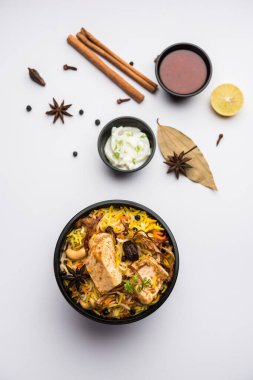 Restoran tarzı Tavuk Tikka Biryani Raita ve Salan ile birlikte plastik kutu veya konteynırda eve teslim edilmek üzere paketlendi.