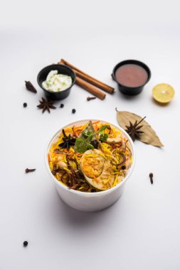 Restoran stili Egg Biryani veya Anda Pulao Raita ve Salan ile birlikte plastik kutu veya konteynırda eve teslim edilmek üzere paketlendi