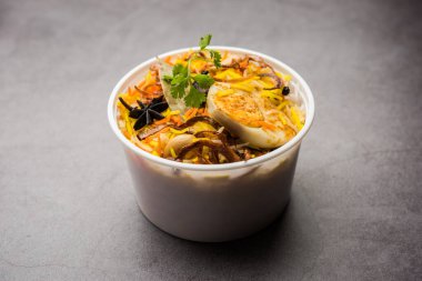 Restoran stili Egg Biryani veya Anda Pulao Raita ve Salan ile birlikte plastik kutu veya konteynırda eve teslim edilmek üzere paketlendi