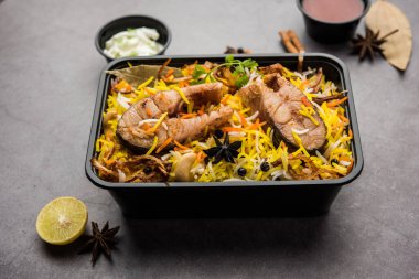 Restoran tarzı Balık Biryani veya Pulao Raita ve Salan 'la birlikte plastik kutu veya konteynırda eve teslim edilmek üzere paketlenmiştir.