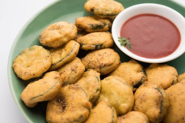 Sünger kabak böreği veya gilki bhaji veya bajji veya pakora domates ketçapı ile servis edilen bir Hint atıştırmalık ürünüdür.