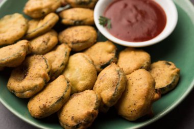 Sünger kabak böreği veya gilki bhaji veya bajji veya pakora domates ketçapı ile servis edilen bir Hint atıştırmalık ürünüdür.