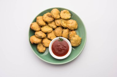 Sünger kabak böreği veya gilki bhaji veya bajji veya pakora domates ketçapı ile servis edilen bir Hint atıştırmalık ürünüdür.