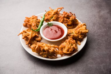 Kızarmış soğan pakora veya Pyaj Pakoda Kıtır Kanda bhaji / Bhajji / bajji olarak da bilinir, yağmur mevsiminde en sevdiği Hint Çay Saati atıştırmalığı. Domates ve ketçap ile servis edilir.