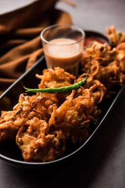 Kızarmış soğan pakora veya Pyaj Pakoda Kıtır Kanda bhaji / Bhajji / bajji olarak da bilinir, yağmur mevsiminde en sevdiği Hint Çay Saati atıştırmalığı. Domates ve ketçap ile servis edilir.