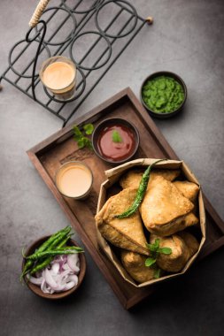 Samosa - Üçgen şeklinde kızarmış / fırında hamur işi, lezzetli dolgulu, popüler Hint çay saati atıştırmalıkları, yeşil turşu, domates ve ketçap ile servis edilen