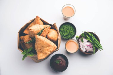 Samosa - Üçgen şeklinde kızarmış / fırında hamur işi, lezzetli dolgulu, popüler Hint çay saati atıştırmalıkları, yeşil turşu, domates ve ketçap ile servis edilen