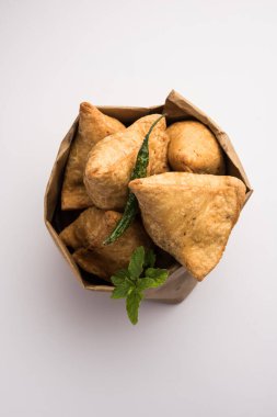 Samosa - Üçgen şeklinde kızarmış / fırında hamur işi, lezzetli dolgulu, popüler Hint çay saati atıştırmalıkları, yeşil turşu, domates ve ketçap ile servis edilen