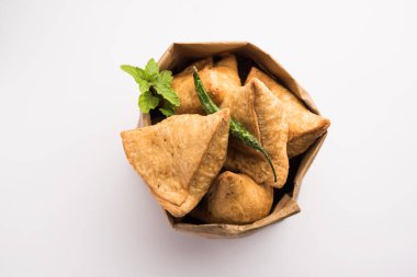 Samosa - Üçgen şeklinde kızarmış / fırında hamur işi, lezzetli dolgulu, popüler Hint çay saati atıştırmalıkları, yeşil turşu, domates ve ketçap ile servis edilen