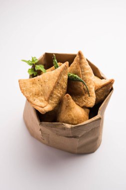 Samosa - Üçgen şeklinde kızarmış / fırında hamur işi, lezzetli dolgulu, popüler Hint çay saati atıştırmalıkları, yeşil turşu, domates ve ketçap ile servis edilen