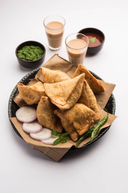 Samosa - Üçgen şeklinde kızarmış / fırında hamur işi, lezzetli dolgulu, popüler Hint çay saati atıştırmalıkları, yeşil turşu, domates ve ketçap ile servis edilen
