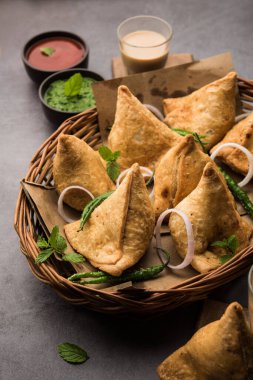 Samosa - Üçgen şeklinde kızarmış / fırında hamur işi, lezzetli dolgulu, popüler Hint çay saati atıştırmalıkları, yeşil turşu, domates ve ketçap ile servis edilen