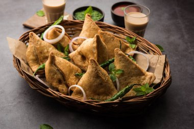 Samosa - Üçgen şeklinde kızarmış / fırında hamur işi, lezzetli dolgulu, popüler Hint çay saati atıştırmalıkları, yeşil turşu, domates ve ketçap ile servis edilen