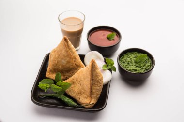 Samosa - Üçgen şeklinde kızarmış / fırında hamur işi, lezzetli dolgulu, popüler Hint çay saati atıştırmalıkları, yeşil turşu, domates ve ketçap ile servis edilen