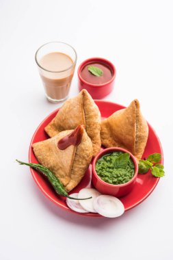 Samosa - Üçgen şeklinde kızarmış / fırında hamur işi, lezzetli dolgulu, popüler Hint çay saati atıştırmalıkları, yeşil turşu, domates ve ketçap ile servis edilen