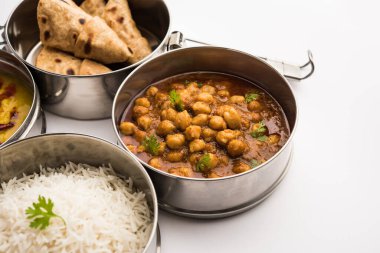 Ofis veya işyeri için paslanmaz çelikten yapılmış Hint vejetaryen beslenme çantası veya Tiffin, Dal Fry, Chole Masala, chapati ve salatalı pilav içerir.