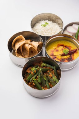 Ofis veya işyeri için paslanmaz çelikten yapılmış Hint vejetaryen beslenme çantası veya Tiffin, Dal Fry, Bhindi Masala, chapati ve salatalı pirinç içerir.