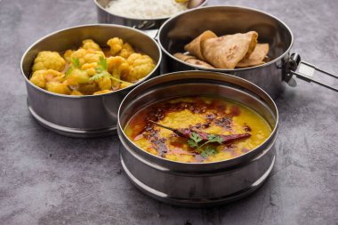 Ofis veya işyeri için paslanmaz çelikten yapılmış Hint vejetaryen beslenme çantası veya Tiffin, Dal Fry, Gobi Masala, chapati ve salatalı pilav içerir.