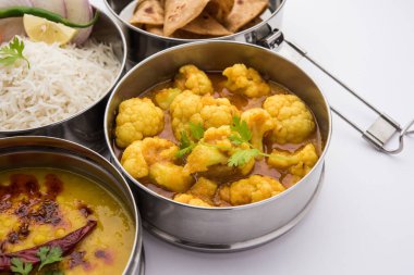 Ofis veya işyeri için paslanmaz çelikten yapılmış Hint vejetaryen beslenme çantası veya Tiffin, Dal Fry, Gobi Masala, chapati ve salatalı pilav içerir.