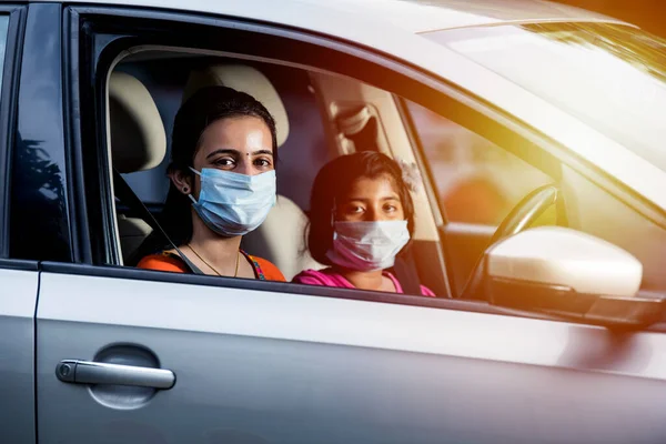 Indian Mother Daughter wearing Face Mask or medical mask while driving car