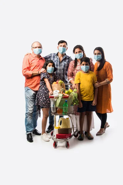 Indian multigeneration Family wearing protective medical face mask during coronavirus and flu outbreak. Virus and illness protection, quarantine. COVID-2019. isolated over white background