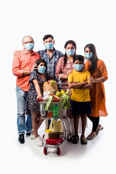 Indian multigeneration Family wearing protective medical face mask during coronavirus and flu outbreak. Virus and illness protection, quarantine. COVID-2019. isolated over white background