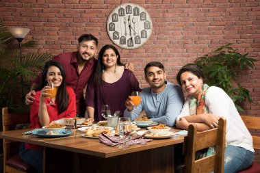 Hintli arkadaşlar restoranda yemek yiyor ya da yemek yiyorlar. Asyalılar bir araya gelme, yeniden birleşme ya da kutlama partisi için yüzlerine bakıyorlar. Kahve Dükkanı Kutlama Dostluğu Konsepti