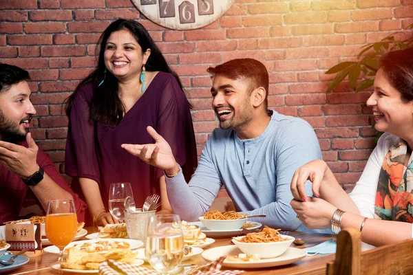 Indian friends eating or dining in restaurant. Asian people in face for get-together, reunion or celebrating party. Coffee Shop Celebration Friendship Togetherness concept