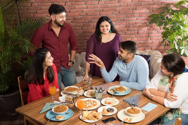 Indian friends eating or dining in restaurant. Asian people in face for get-together, reunion or celebrating party. Coffee Shop Celebration Friendship Togetherness concept