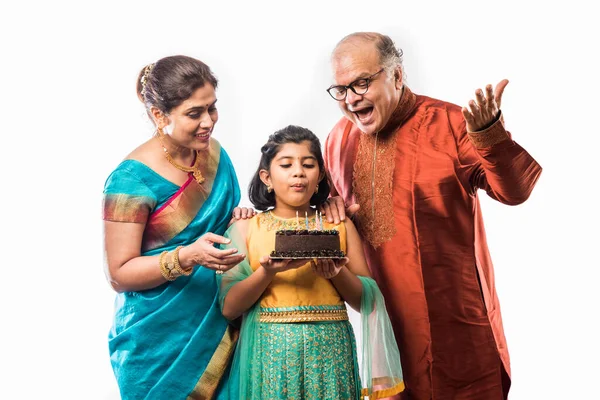 Küçük şirin bir Hintli kız torun ya da kız doğum gününü büyükannesi ve büyükbabasıyla kutlarken etek giyiyormuş.
