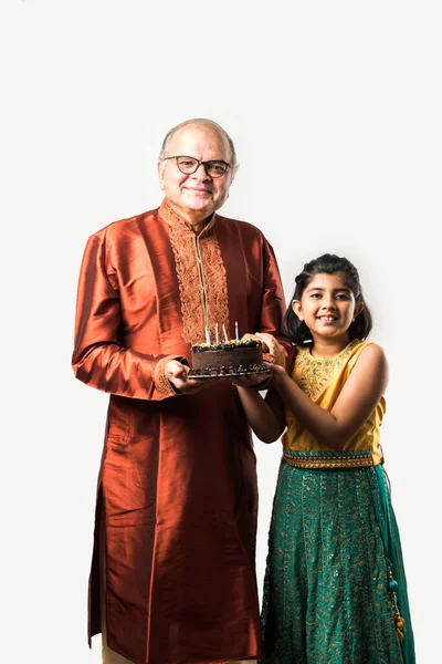 인도의 시니어나 손녀딸과 민족적 배경에 고립되어 케이크 촛불을 생일을 축하하는 — 스톡 사진