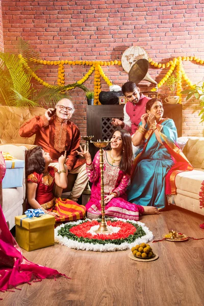 ハッピー インディア ファミリー セレブレーション ガネッシュ フェスティバルまたはチャトゥティ ポヤを歓迎または実行し マリーゴールドの花で飾られた自宅で伝統的な服でお菓子を食べる — ストック写真