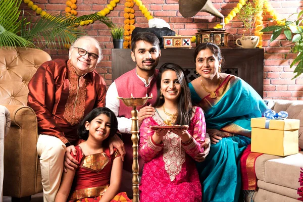 Ganesh Festivali 'ni ya da Chaturthi' yi kutlayan mutlu Hint Ailesi - Hoş geldiniz ya da Pooja 'yı sahneleyen ve geleneksel olarak Marigold Çiçekleri ile süslenmiş evde şekerleme yiyen