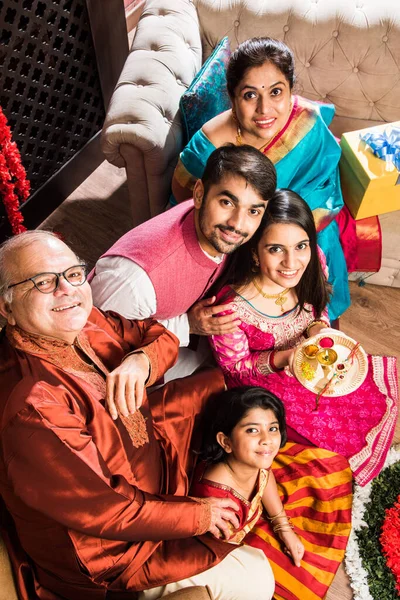 庆祝Ganesh节或Chaturthi的快乐印度家庭 欢迎或表演Pooja 并在家里享用装饰有Marigold花的传统服饰中的糖果 — 图库照片