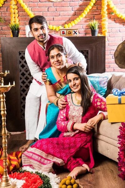 Ganesh Festivali 'ni ya da Chaturthi' yi kutlayan mutlu Hint Ailesi - Hoş geldiniz ya da Pooja 'yı sahneleyen ve geleneksel olarak Marigold Çiçekleri ile süslenmiş evde şekerleme yiyen